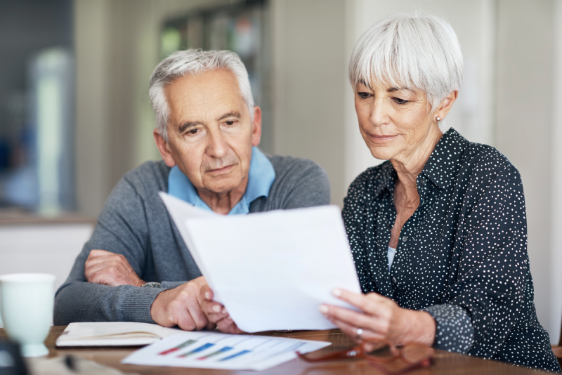 Senior couple reviewing financial documents to plan for retirement