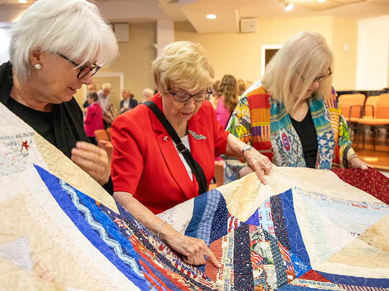 Dr. Marilyn "Dee" Ray admires her quilt.