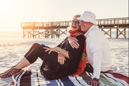 Retired couple smiling on a beach