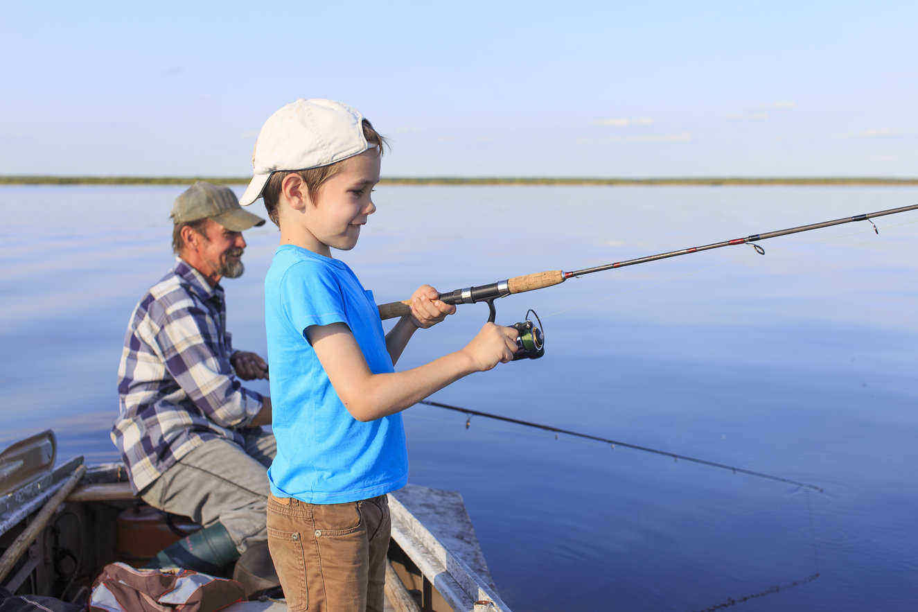 Grandfather and grandson fishing on boat