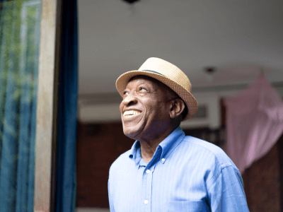 African American senior smiling while looking out a window
