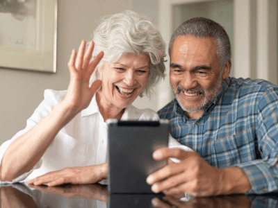 Senior couple using electronic tablet to video chat