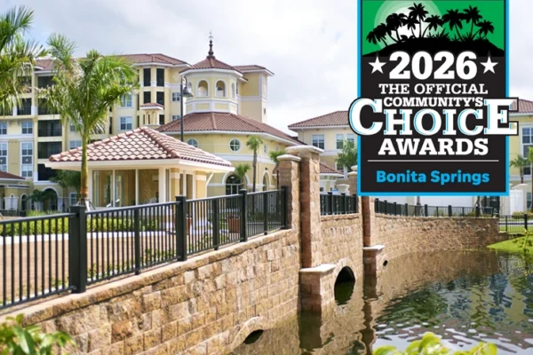 A Mediterranean-style building by a canal with palm trees, alongside a 2026 Bonita Springs Community’s Choice Awards graphic in the upper right corner.